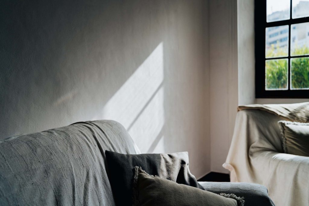 Salón luminoso con sofás beige y cojines en tonos neutros iluminados por luz natural